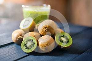 glass of kiwi juice with fresh fruits on wooden table