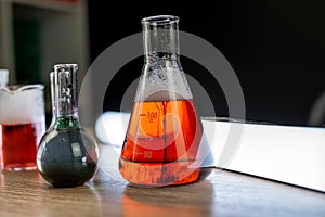 Glass laboratory flask and beaker with liquids for analys or experiment in desk