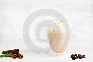 Glass of latte with cinnamon and coffee beans