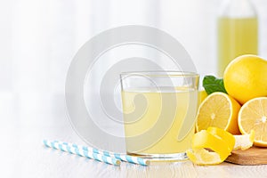 A glass of lemon juice and lemons