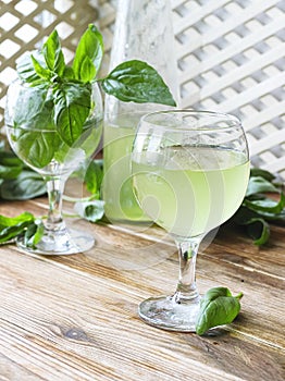 Glass of lemonade made from green basil and lemon