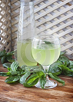 Glass of lemonade made from green basil and lemon