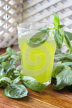 Glass of lemonade made from green basil and lemon