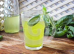 Glass of lemonade made from green basil and lemon