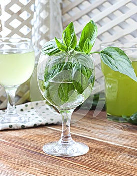 Glass of lemonade made from green basil and lemon