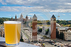 Glass of light beer against view of Spain Square Placa d`Espanya in Barcelona, Spain. Aerial view of Placa d`Espanya with photo