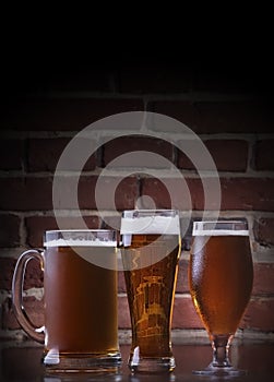 Glass of light beer on a dark pub.