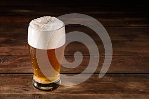 Glass of light beer on a dark pub. Glass beer on wood background with copy space