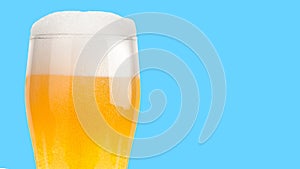 Glass of light beer isolated on blue