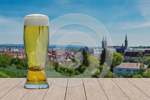 Glass of light beer on panoramic view of fields and historic old town of Bamberg, Germany