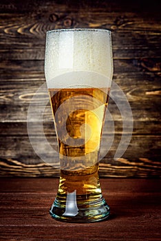 Glass of light beer on a pub with bokeh background