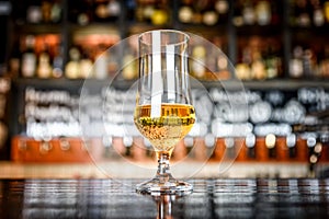 Glass of light beer on a pub with bokeh background