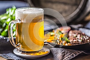 Glass of light beer in pub or restavurant on table with delicoius food