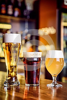 Glass of light and dark beer on a pub with bokeh background