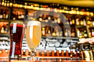 Glass of light and dark beer on a pub with bokeh background