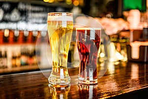 Glass of light and dark beer on a pub with bokeh background