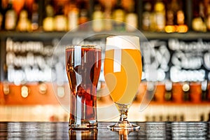 Glass of light and dark beer on a pub with bokeh background