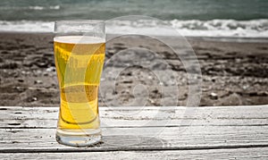 Glass of light golden Pilsner ale on rustic table