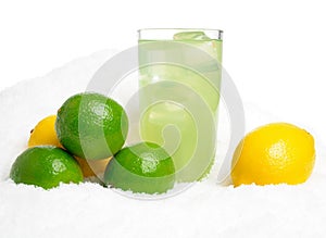 Glass of lime juice with ice cubes,limes,lemons on snow on white