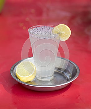 Glass of lime water or lemonade on a red  plastic top