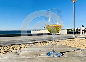 Glass with limonade wooden table  on the beach in sea port blue sky  sun beam reflection and  scene