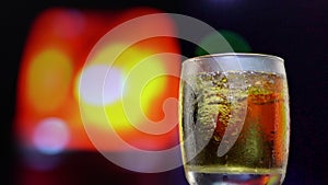 The glass of liqueur is spinning with a backdrop of sirens