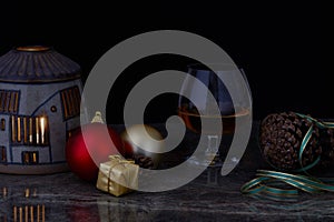 Glass of liquor on decorated Christmas table with black background