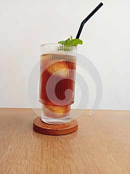 a glass of lychee iced tea garnished with mint leaves