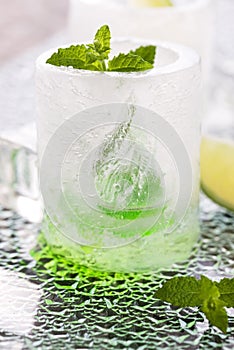 Glass made of ice with vodka, lemon and mint