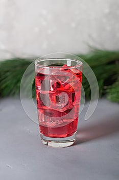 Glass of mango dragonfruit refresher drink on table with ice cubes. Copy space