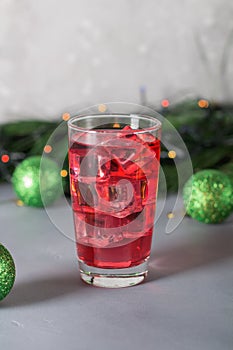 Glass of mango dragonfruit refresher drink on table with ice cubes. Copy space