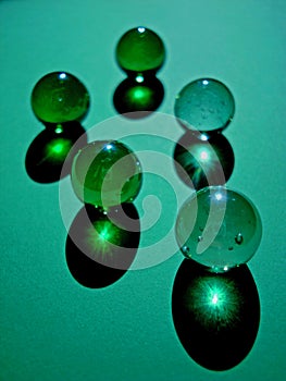 Glass marble balls on green background