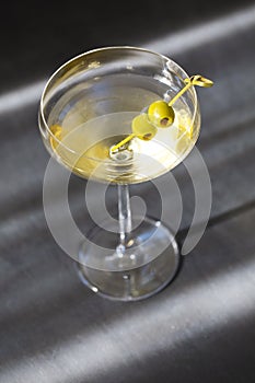 Glass with martini and green olives