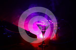 Glass with martini with olive inside on dj controller in night club. Dj Console with club drink at music party in nightclub with d