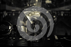 Glass with martini with olive inside on dj controller in night club. Dj Console with club drink at music party in nightclub with d