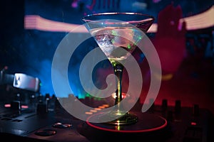 Glass with martini with olive inside on dj controller in night club. Dj Console with club drink at music party in nightclub with d