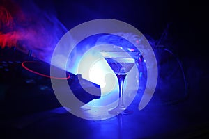 Glass with martini with olive inside on dj controller in night club. Dj Console with club drink at music party in nightclub with d