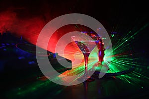 Glass with martini with olive inside on dj controller in night club. Dj Console with club drink at music party in nightclub with d