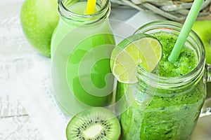 Glass Mason Jar and Bottle with Green Vegetable and Fruit Smoothie and Juice with Straw. Basket with Seasonal Organic Produce