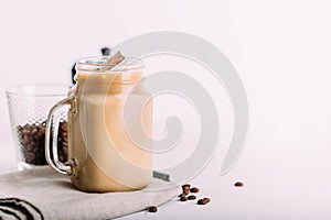 Glass mason jar with ice coffee with milk