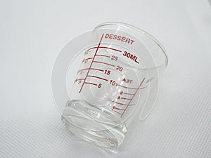 Glass measuring cup on white background