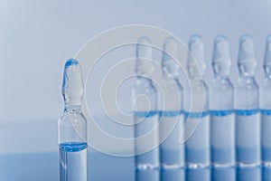 Glass medical ampoule vial for injection. Medicine is liquid sodium chloride with of aqueous solution in ampulla. Close