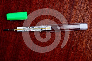 Glass medical thermometer in a case on the table