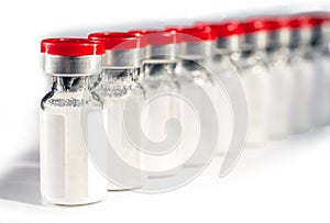 Glass medical vials of biotech drugs. With red caps. photo