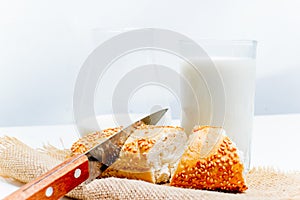 A glass of milk with bread and grains