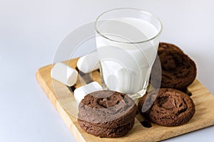 Glass of milk and Chocolate Cookies with Marshmallow Concept for a Tasty Snack Sweet Dessert Blue Background