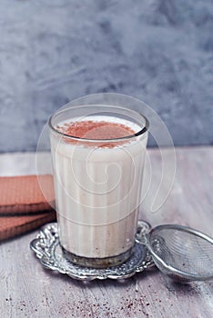 A glass of Milk with cinnamon or cocoa Powder with biscuits on rustic background. Healthy Breakfast.