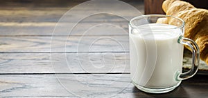 Glass of milk with a croissant with copy space