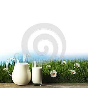 Glass of milk and jar on flower meadow