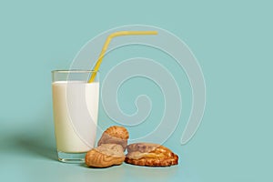 A glass of milk, plastic tube and cakes